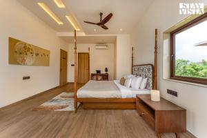a bedroom with a bed and a window at StayVista at Villa Alora with Jacuzzi in Lonavala +24 photos
