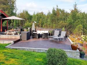 a patio with chairs and a table and an umbrella at Cozy Cottage Retreat in Trend-By Traum in Frei