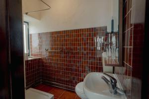 a bathroom with a sink and a toilet and red tiles at Best Houses 51 - Casa das Marés I - Berlenga in Ferrel +17 photos