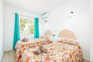 two beds in a bedroom with blue curtains at Gran Sol Family 2 in Felanitx