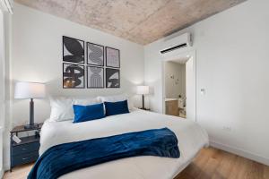 a bedroom with a large white bed with blue pillows at Corporate-Friendly 4BR Stylish & Central in Chicago