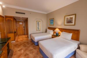 a hotel room with two beds and a couch at Old Palace Resort Sahl Hasheesh in Hurghada