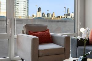 a living room with a chair and a window at Corporate-Friendly 4BR Stylish & Central in Chicago