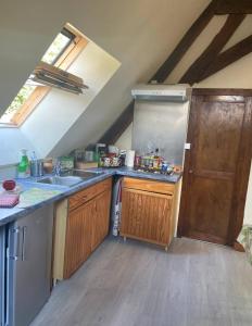 a kitchen with wooden cabinets and a sink and a door at Cœur de Loire in Nevers