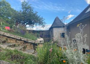 a garden with a stone wall and some flowers at Cœur de Loire in Nevers