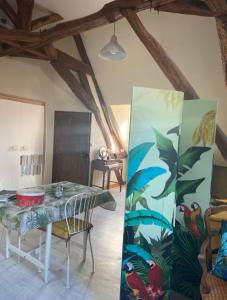 a dining room with a table with a painting on the wall at Cœur de Loire in Nevers