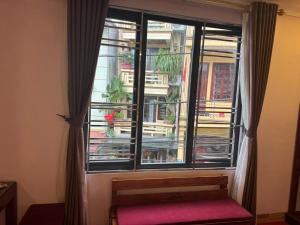 a window with a red bench in front of a building at Amlysa Sapa Hotel 2 in Sa Pa