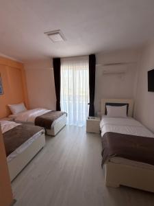 Un dormitorio con dos camas y una ventana. en Oruci hotel, en Kukës 5 fotos más