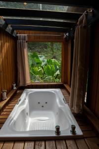 eine Badewanne in einem Raum mit Fenster in der Unterkunft Cabana Haere Tonu- Seu Refúgio no Coração do Vale Europeu in Benedito Novo + 72 Fotos