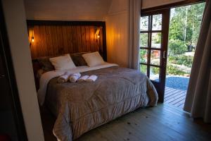 ein Schlafzimmer mit einem Bett mit zwei Hausschuhen darauf in der Unterkunft Cabana Haere Tonu- Seu Refúgio no Coração do Vale Europeu in Benedito Novo