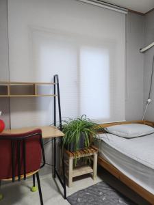 a bedroom with a bed and a desk and a chair at Lucky House in Busan