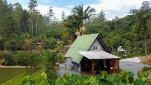 ein kleines Haus mit grünem Dach in einem Wald in der Unterkunft Cabana Haere Tonu- Seu Refúgio no Coração do Vale Europeu in Benedito Novo