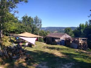 a tent and a pile of wood in a field at La Vintage insolite in Lacaze