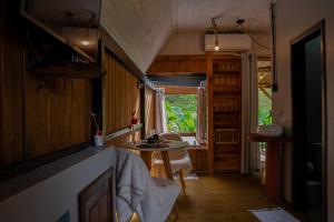 eine Küche mit einem Tisch und einem Fenster in einem Zimmer in der Unterkunft Cabana Haere Tonu- Seu Refúgio no Coração do Vale Europeu in Benedito Novo