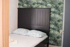 a bed with a black headboard and two pillows at Apartments Silver in Novalja