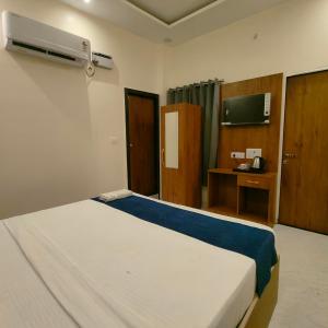 Un dormitorio con cama, escritorio y televisión. en Hotel Ramayan Elite 2 KM Shree Ram Ji Mandir and Free Pickup From Ayodhya Dham Railway Station, en Ayodhya