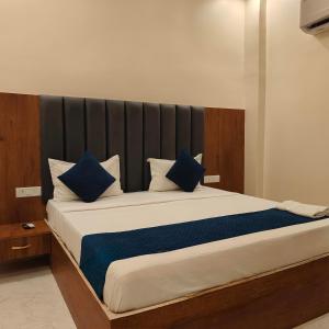 Un dormitorio con una cama grande con almohadas azules. en Hotel Ramayan Elite 2 KM Shree Ram Ji Mandir and Free Pickup From Ayodhya Dham Railway Station, en Ayodhya