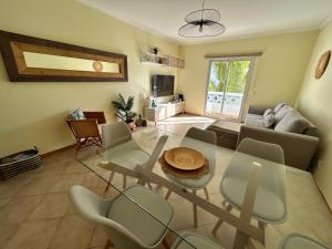 a living room with a glass table and chairs at Porto Santo Rentals in Porto Santo