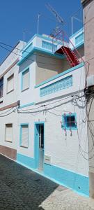 a white and blue building with a blue door at Casa Fuseta-38 in Fuzeta +1 photo