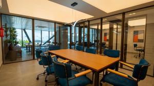 einen Konferenzraum mit einem Holztisch und blauen Stühlen in der Unterkunft Vento Terral - 42m, Novo, Alto Padrão, Frente Mar in Fortaleza + 28 Fotos