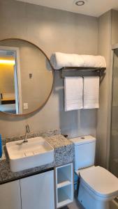 ein Badezimmer mit Waschbecken, Toilette und Spiegel in der Unterkunft Vento Terral - 42m, Novo, Alto Padrão, Frente Mar in Fortaleza