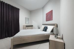 a bedroom with a bed and a table with a lamp at High End 2 Bedroom Apartment St Julians in St Julian's