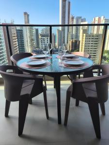einen Tisch mit Weingläsern und Stühlen auf dem Balkon in der Unterkunft Vento Terral - 42m, Novo, Alto Padrão, Frente Mar in Fortaleza