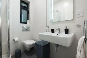 a white bathroom with a sink and a toilet at High End 2 Bedroom Apartment St Julians in St Julian's +34 photos