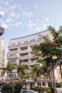 a large building with palm trees in front of it at High End 2 Bedroom Apartment St Julians in St Julian's