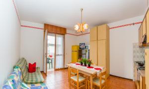 a living room with a table and a couch at Residence Sabrina in Bibione +8 photos