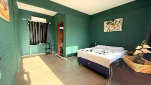 a bedroom with green walls and a bed in a room at pousada calango in Aracati