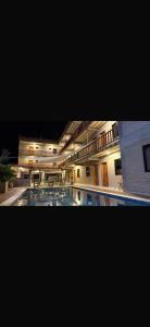 a large building with a swimming pool at night at pousada calango in Aracati