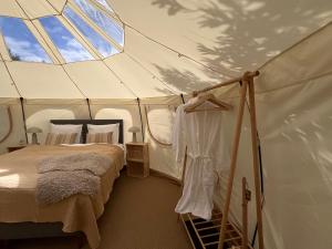 a bedroom with a bed in a tent at Agger Glamping - Havtornen in Vestervig