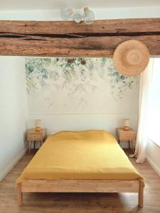 a bedroom with a yellow bed with two tables at Petite maison cosy à Moret-sur-Loing, cour privée in Moret-sur-Loing