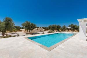 a swimming pool in a villa with trees in the background at Tenuta Manfredi by Perle di Puglia in Latiano