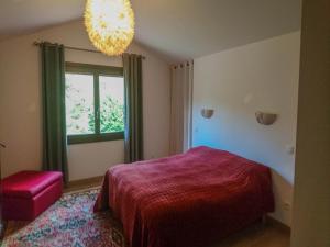 a bedroom with a bed and a window and a chandelier at Villa in Bruniquel by Aveyron River in Bruniquel