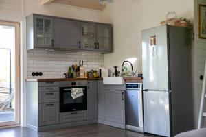 a kitchen with stainless steel appliances and a refrigerator at Vizbules in Turaida +7 photos