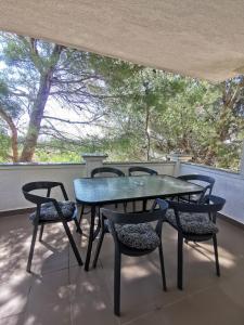 a blue table and chairs on a balcony with trees at Apartments Silver in Novalja