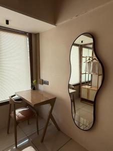 a mirror on the wall of a room with a table at Ikigai 2Bhk Furnished Apartment Soothing Vibes in Navi Mumbai