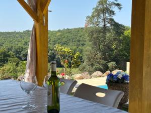 a bottle of wine sitting on a table with a glass at Chateau De La Ricardie, Gite La Ricardie, Beautiful Rural Property Gite Villa in Liorac