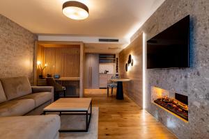 ein Wohnzimmer mit Couch und Kamin in der Unterkunft Pfalzblick Wald Spa Resort in Dahn