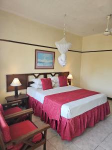 um quarto com uma cama grande e duas cadeiras em Indiana Beach Apartments em Bamburi mais 61 fotografias