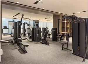 une salle de sport avec plusieurs tapis de course et machines cardio dans l'établissement Grande Downtown Dubai - Luxury 1BR Apt near Burj khalifa and Dubai Mall, à Dubaï