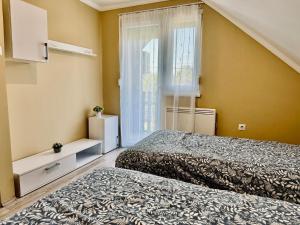 a bedroom with two beds and a window at Betti in Balatonkeresztúr