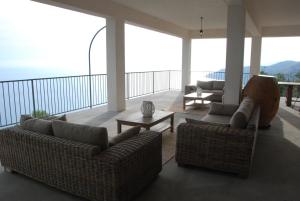 ein Wohnzimmer mit Sofas und Tischen auf dem Balkon in der Unterkunft Santo Mercurio Country House in Pisciotta