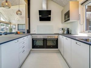 a kitchen with white cabinets and black counter tops at 5 star holiday home in Kappeln in Kappeln