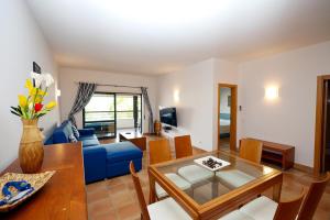 ein Wohnzimmer mit einem blauen Sofa und einem Tisch in der Unterkunft B39 - Marina Hill Apartment in Lagos