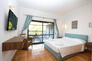 ein Schlafzimmer mit Bett, Fernseher und Balkon in der Unterkunft B39 - Marina Hill Apartment in Lagos + 35 Fotos