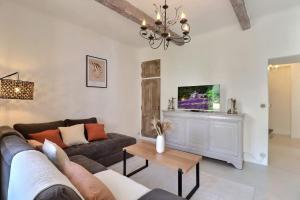 a living room with a couch and a tv at L’oustaou de Ventabren Village Square in Ventabren