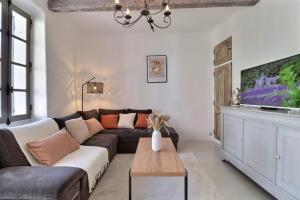 a living room with a couch and a tv at L’oustaou de Ventabren Village Square in Ventabren
